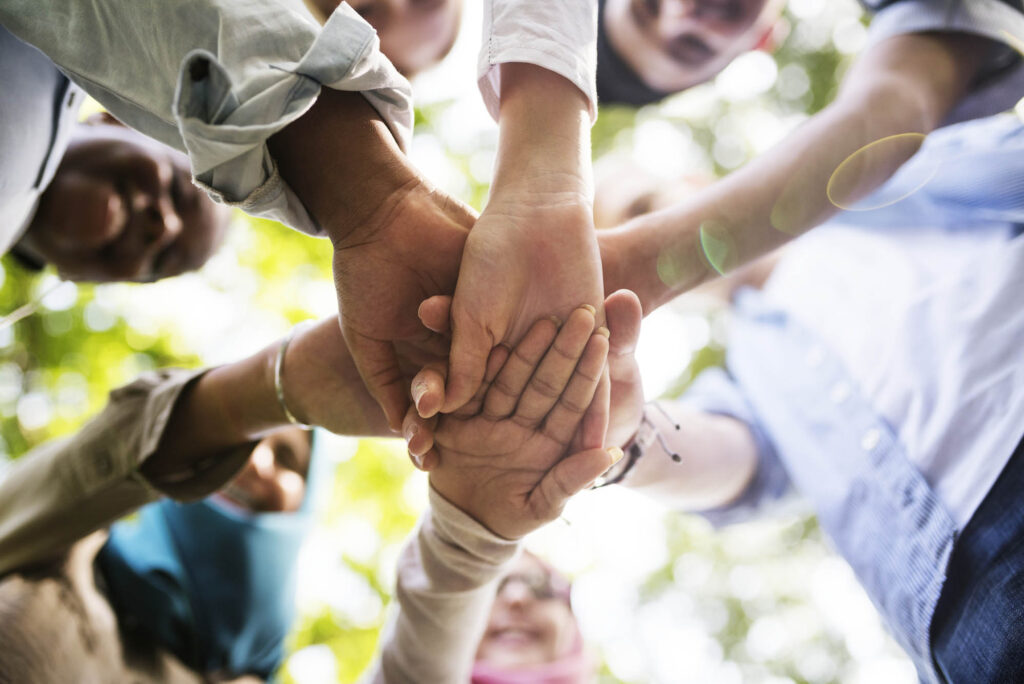 Solentra Wellness | Group of diverse youth hands joined