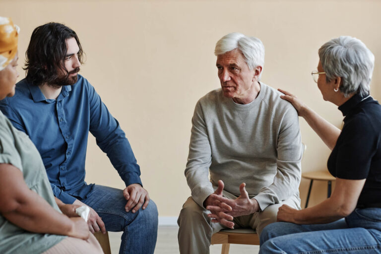 Solentra Wellness | White haired man sharing troubles in mental health support group